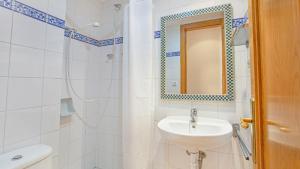 a white bathroom with a sink and a mirror at 1 Monts - Llafranc in Llafranc +11 photos