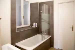 a bathroom with a bath tub and a mirror at Appartement Le bain aux plantes in Strasbourg +22 photos