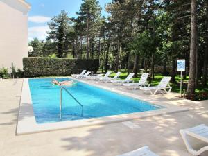 einen Pool mit Liegestühlen und eine Person, die darin liegt in der Unterkunft Apartment Villa Anna-4 by Interhome in Jadranovo