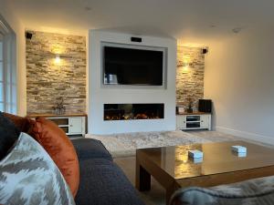 a living room with a couch and a fireplace at Luxurious 4 bedroom home in the heart of the Cotswolds with Hot Tub! in Stow on the Wold