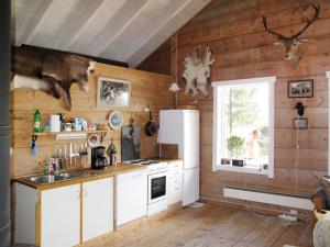 にあるChalet Svanöy by Interhomeの木製の壁、白い冷蔵庫付きのキッチン