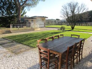 a wooden table and chairs in a yard at Holiday Home Quercitella by Interhome in Certaldo