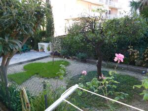 un jardín con un árbol y flores rosas en Apartment Alessandro by Interhome, en Diano Marina