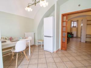 eine Küche mit einem weißen Kühlschrank und einem Tisch in der Unterkunft Apartment Kiwi e L'uva by Interhome in Fabrica di Roma