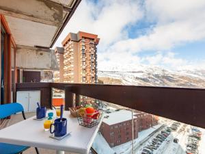 a table on a balcony with a view of a city at Apartment Lunik Orion-48 by Interhome in Le Corbier