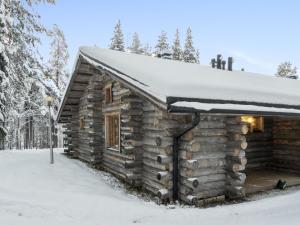 a log cabin with a snow covered roof at Holiday Home Sallan savu a by Interhome in Salla