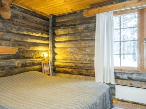 a bedroom with a bed in a log cabin at Holiday Home Sallan savu a by Interhome in Salla