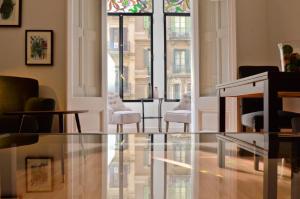 een woonkamer met stoelen en een glazen tafel bij Way to BCN Casa Rovira in Barcelona