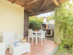 un patio con mesa, sillas y parrilla en Apartment Stella con piscina comune - REI100 by Interhome, en Costa Rei