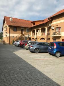 a group of cars parked in a parking lot in front of a building at Royal Hotel in Cserkeszőlő