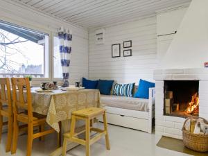 ein Wohnzimmer mit Tisch und Kamin in der Unterkunft Holiday Home Lepola by Interhome in Vaskivesi