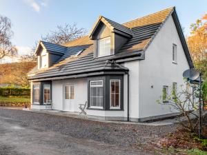 uma casa branca com um telhado preto em Holiday Home Loch Ness House by Interhome em Drumnadrochit