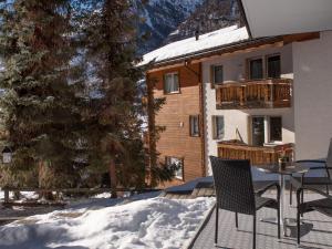 einen Balkon mit einem Tisch und Stühlen im Schnee in der Unterkunft Apartment Hubertus-1 by Interhome in Zermatt