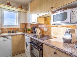 een keuken met een fornuis en een magnetron bij Apartment Eskola-2 by Interhome in Bidart