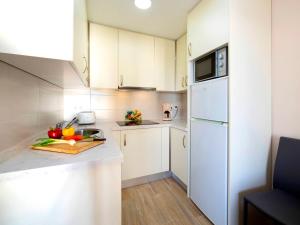 eine Küche mit weißen Schränken und einem weißen Kühlschrank in der Unterkunft Apartment Costa Blanca II by Interhome in Calpe