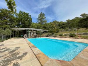 a blue swimming pool with a gazebo at Gîte "Bois-Mariage" in Mollans-sur-Ouvèze