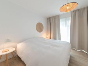 a white bedroom with a white bed and a window at Apartment Miramar by Interhome in Ostend
