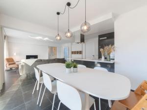 a dining room and kitchen with a white table and chairs at Apartment Miramar by Interhome in Ostend