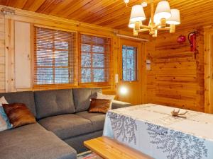 a living room with a couch and a table at Holiday Home Tunturitupa kuolpuna by Interhome in Raattama