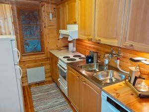 a kitchen with a sink and a stove at Holiday Home Tunturitupa kuolpuna by Interhome in Raattama +12 photos