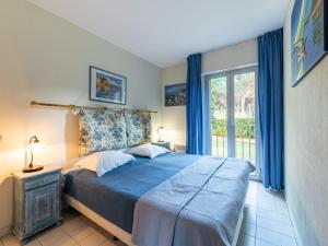 - une chambre avec un lit doté de draps bleus et une fenêtre dans l'établissement Apartment Caesar Domus-5 by Interhome, à Saint-Tropez