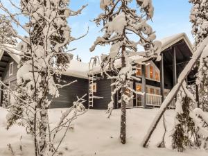 a house covered in snow with a tree at Holiday Home Tiera by Interhome in Salla