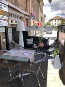 un patio con tavoli e sedie su un balcone di Hôtel Restaurant de Londres a Saint-Just-en-Chevalet