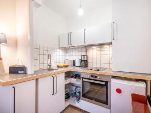 una cocina con armarios blancos y electrodomésticos blancos en Studio Trouz Ar Mor-3 by Interhome, en Quiberon