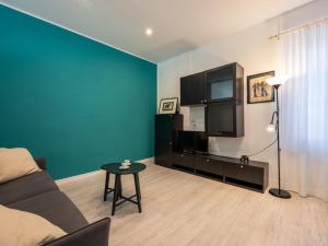 uma sala de estar com um sofá, uma televisão e uma mesa em Apartment Giardino del Bosso-4 by Interhome em Germignaga