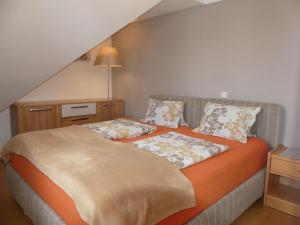 - une chambre avec un lit et une couverture orange dans l'établissement Apartment Das Stadthaus-2 by Interhome, à Saalfelden