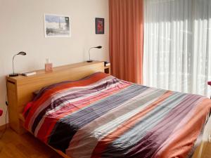 a bedroom with a bed with two lamps and a window at Apartment Golf C by Interhome in Leukerbad