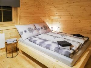 a bed in a wooden room with a wooden wall at Chalet Chalet Amsel by Interhome in Hochrindl