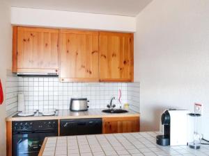 - une cuisine avec des placards en bois et une cuisinière dans l'établissement Apartment Hauts de Nendaz A F3 by Interhome, à Nendaz