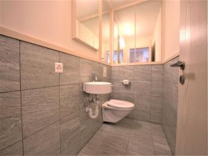 a bathroom with a toilet and a sink at Apartment Chesa Sur Ova 22 by Interhome in St. Moritz
