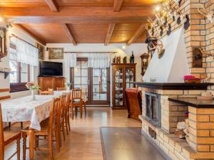 uma sala de jantar com lareira, mesa e cadeiras em Holiday Home Jelení kout by Interhome em Smržovka