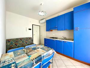 una cocina azul con armarios azules y fregadero en Rialto, en Lignano Sabbiadoro