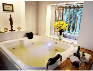 a bath tub with a sink and a window at ASGARD Spa in San Agustín