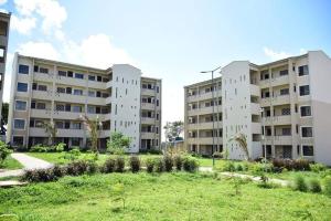 two apartment buildings with a park in the middle at Kiki's @ Palm Ridge-Vipingo in Kilifi
