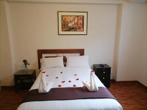 a bedroom with a bed with shoes on it at Hostal Premier Inn in Machu Picchu