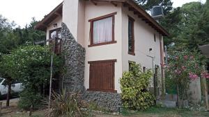 una casa con una porta in legno e alcuni fiori di Sueño del Bosque a Santa Teresita