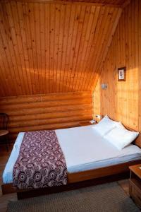 ヘルソンにあるGostiniy Dvor Non-Stopの木製の部屋にベッド1台が備わるベッドルーム1室があります。