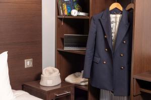 a coat hanging on a rack in a bedroom at Hôtel L'Interlude in Paris