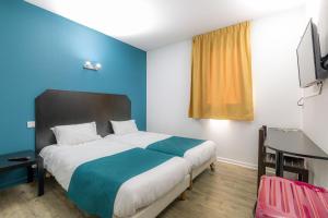 a bedroom with a large bed with a blue wall at Audotel in Carcassonne