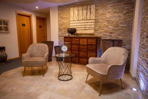 duas cadeiras e uma mesa num quarto com uma parede de tijolos em Guesthouse Bocage em Setúbal
