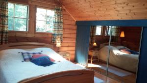 um quarto com 2 camas num chalé de madeira em Vila Dovilas em Palanga