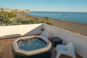 a hot tub on a balcony with a view of the beach at Apartamentos Varadero On the beach in Cala del Moral