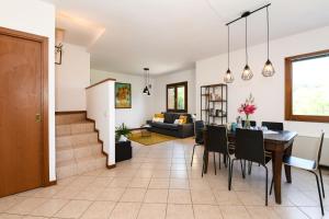 een eetkamer en woonkamer met een tafel en stoelen bij Villa Rosa in Manerba del Garda