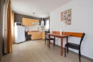 a small kitchen with a table and a refrigerator at Cabañas Campanario in La Serena