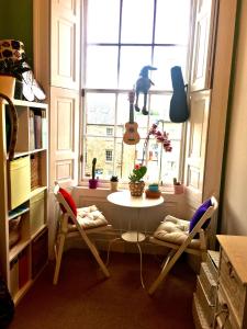 a table and chairs in a room with a window at Spacious and cozy apartment in the heart of Haddington in Haddington