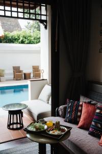 ein Wohnzimmer mit einem Tisch und Teller mit Lebensmitteln darauf in der Unterkunft T Heritage Hotel in Chiang Mai